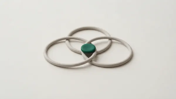 Three overlapping grey clay rings with a small green disc where all three meet