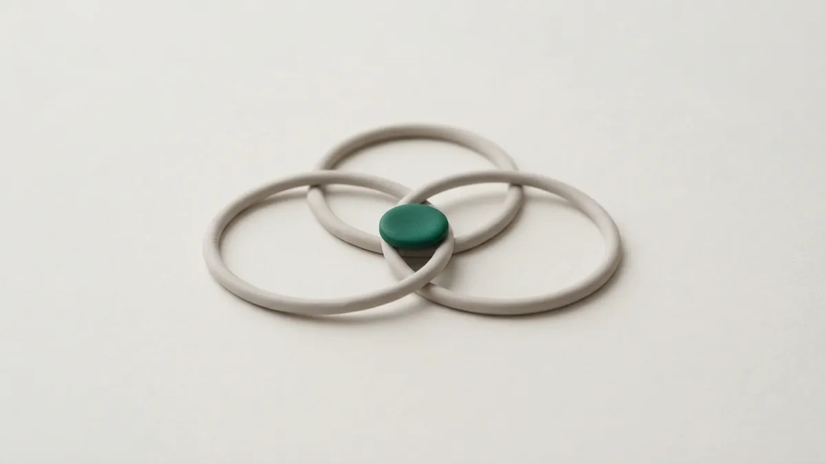 Three overlapping grey clay rings with a small green disc where all three meet